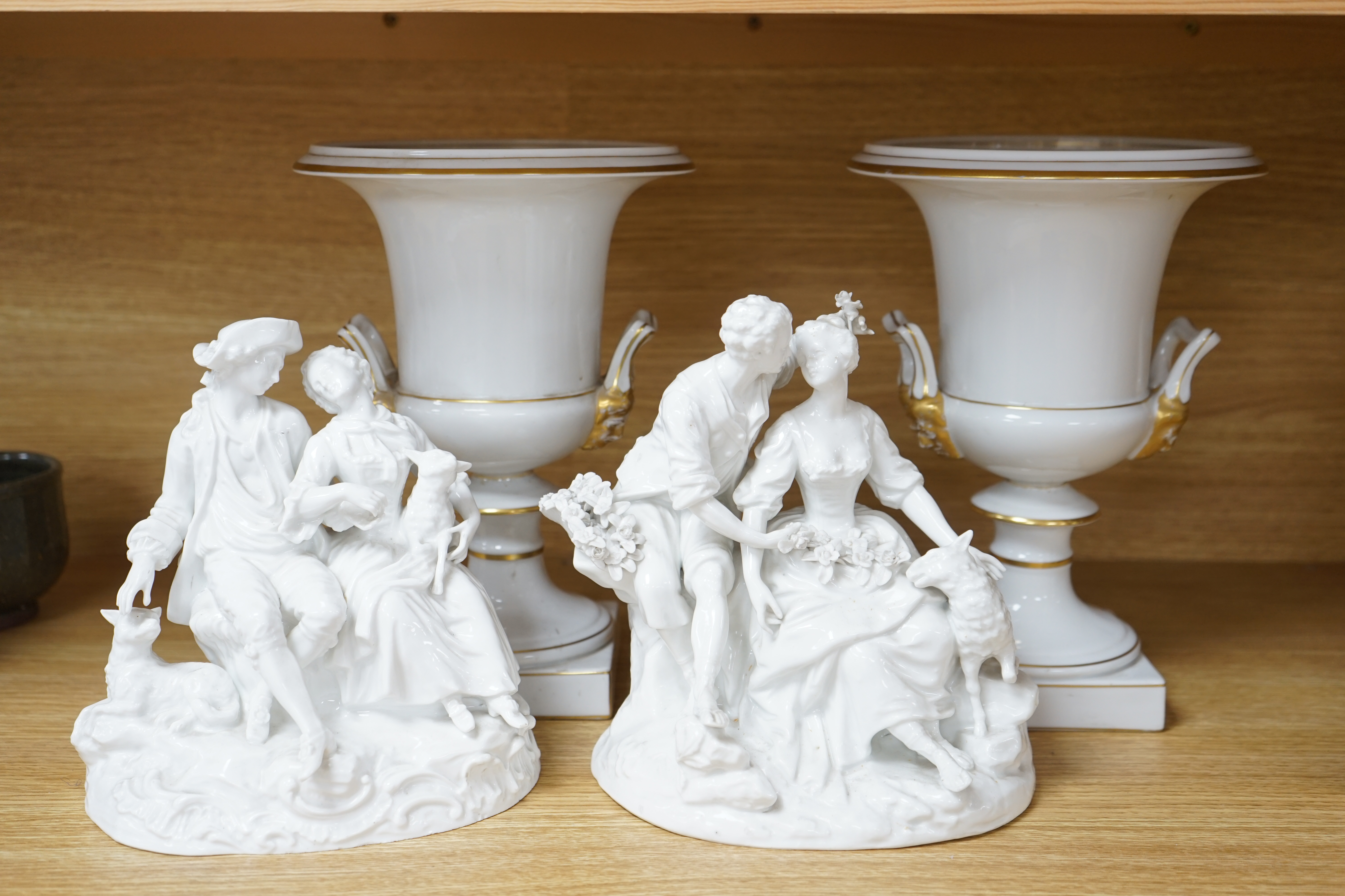 Two Meissen style figure groups, tallest 21cm, and a pair of urns, 26.5cm.